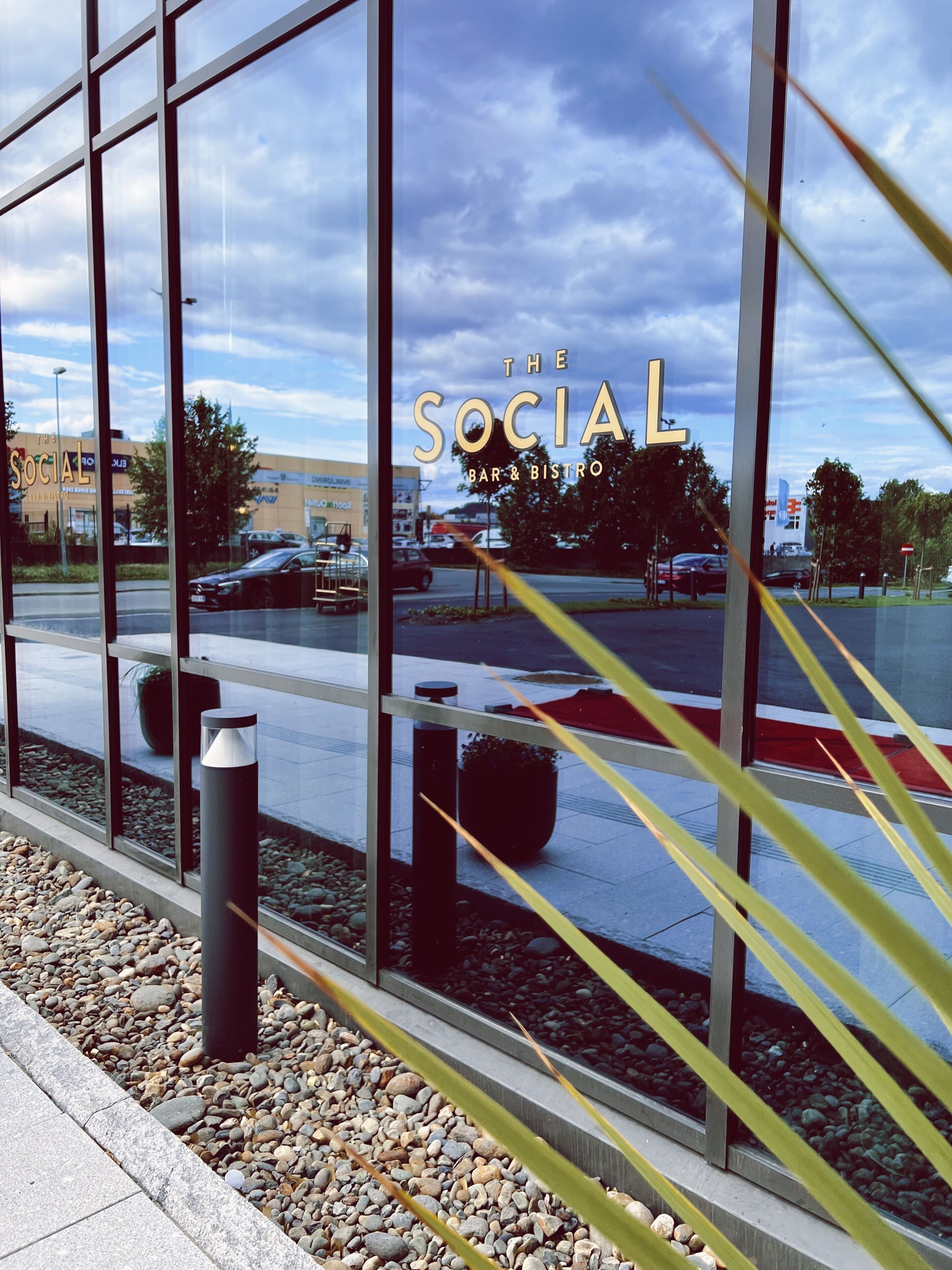 A modern building with large windows and a sign reading "The Social Bar & Bistro".