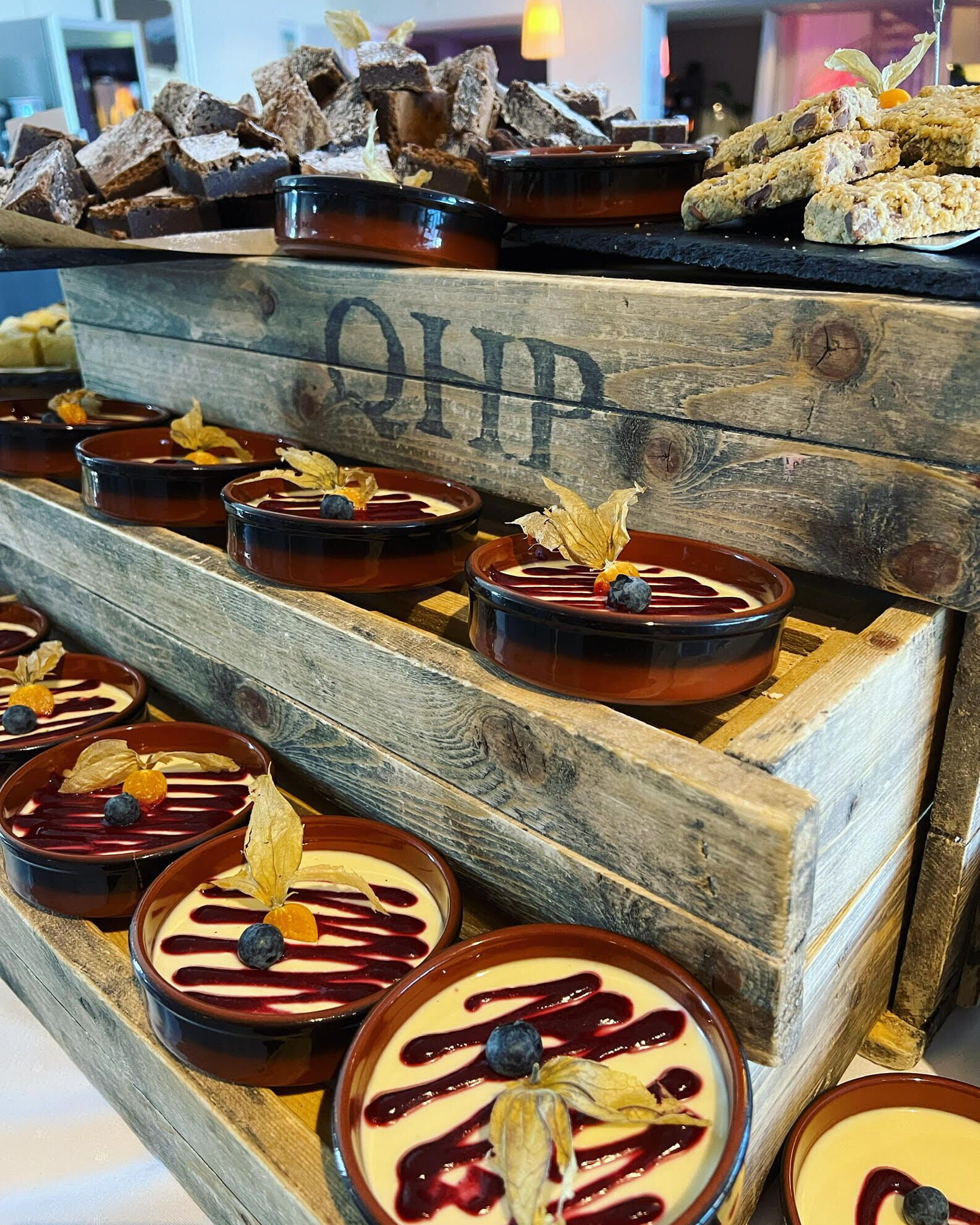 Postres en recipientes de cerámica, dispuestos sobre un flete de madera.