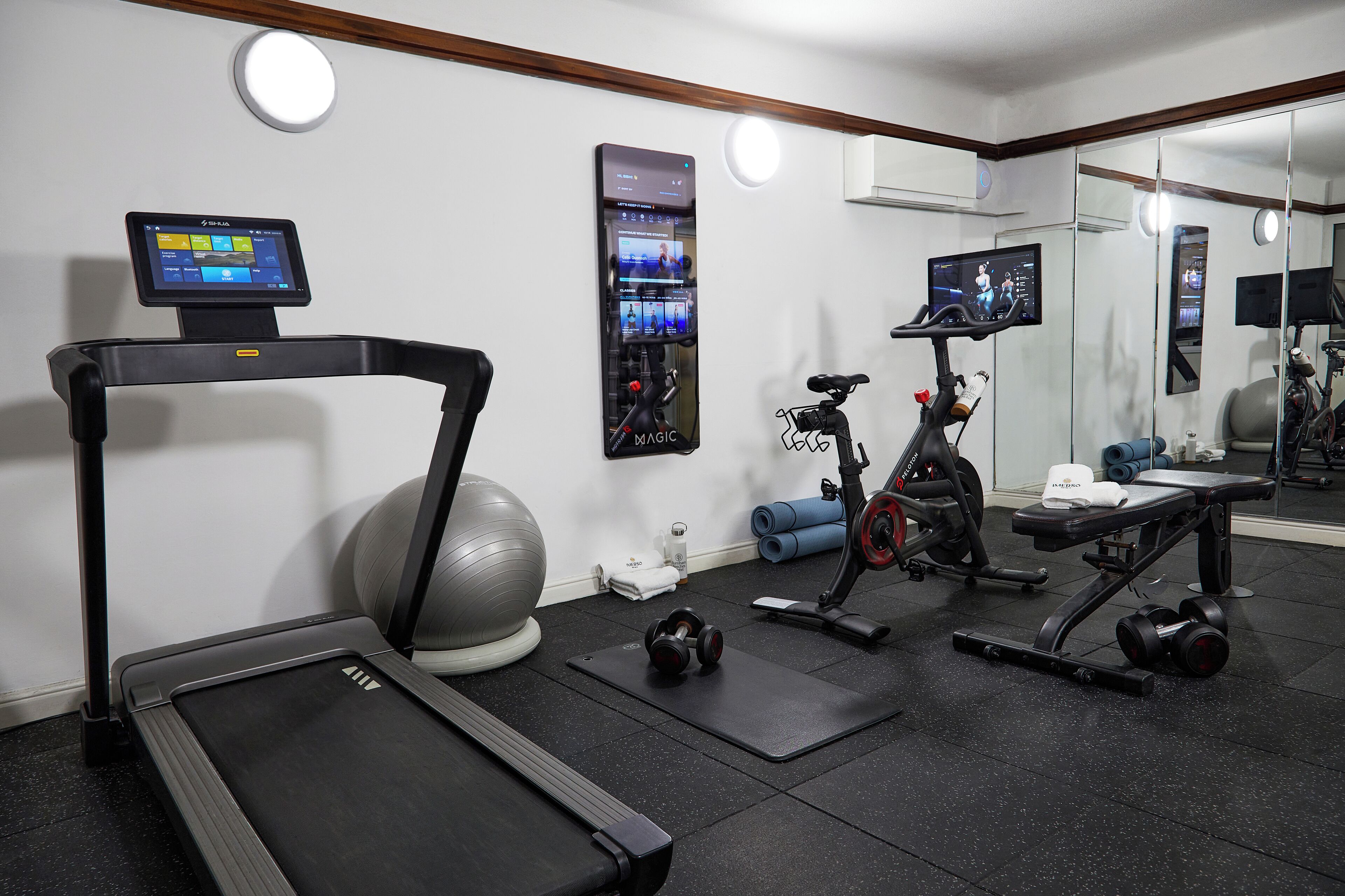 Et moderne fitnessrum med løbebånd, motionscykel og forskellige vægte.