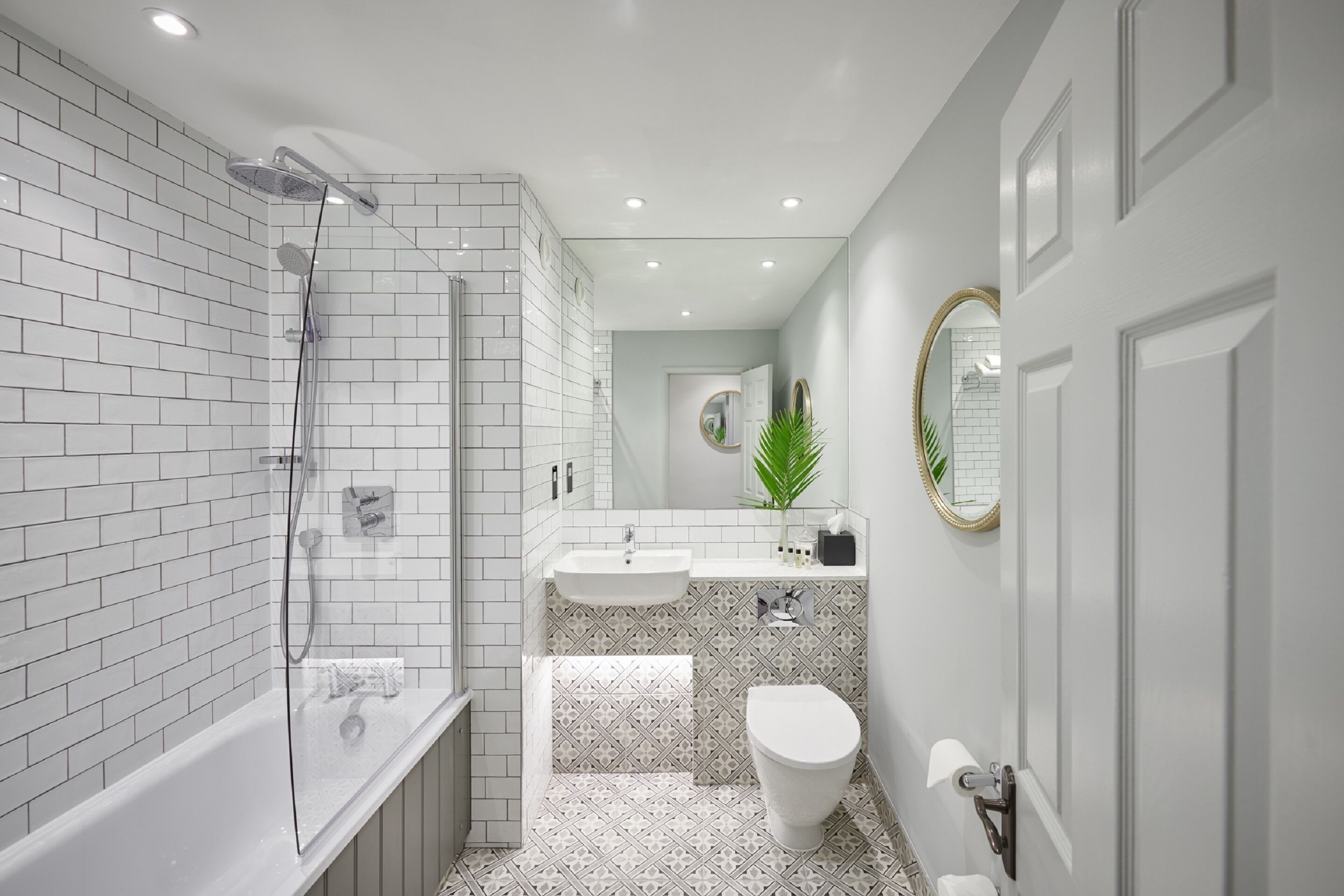 Un baño moderno con ducha acristalada, un lavabo blanco y un inodoro.