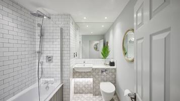Un baño moderno con ducha acristalada, un lavabo blanco y un inodoro.