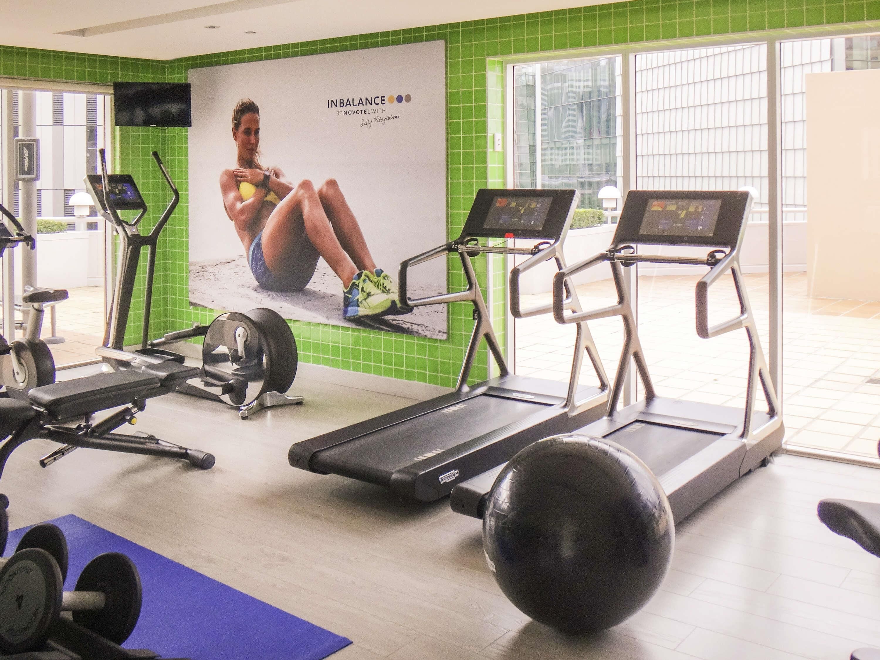 A gym with treadmills, a stationary bike, and a weight bench.