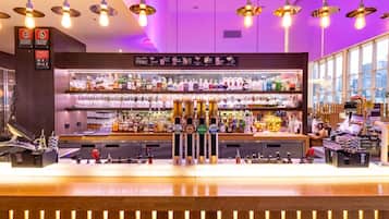A bar area with a variety of liquor bottles, a selection of glasses, and a bar counter.
