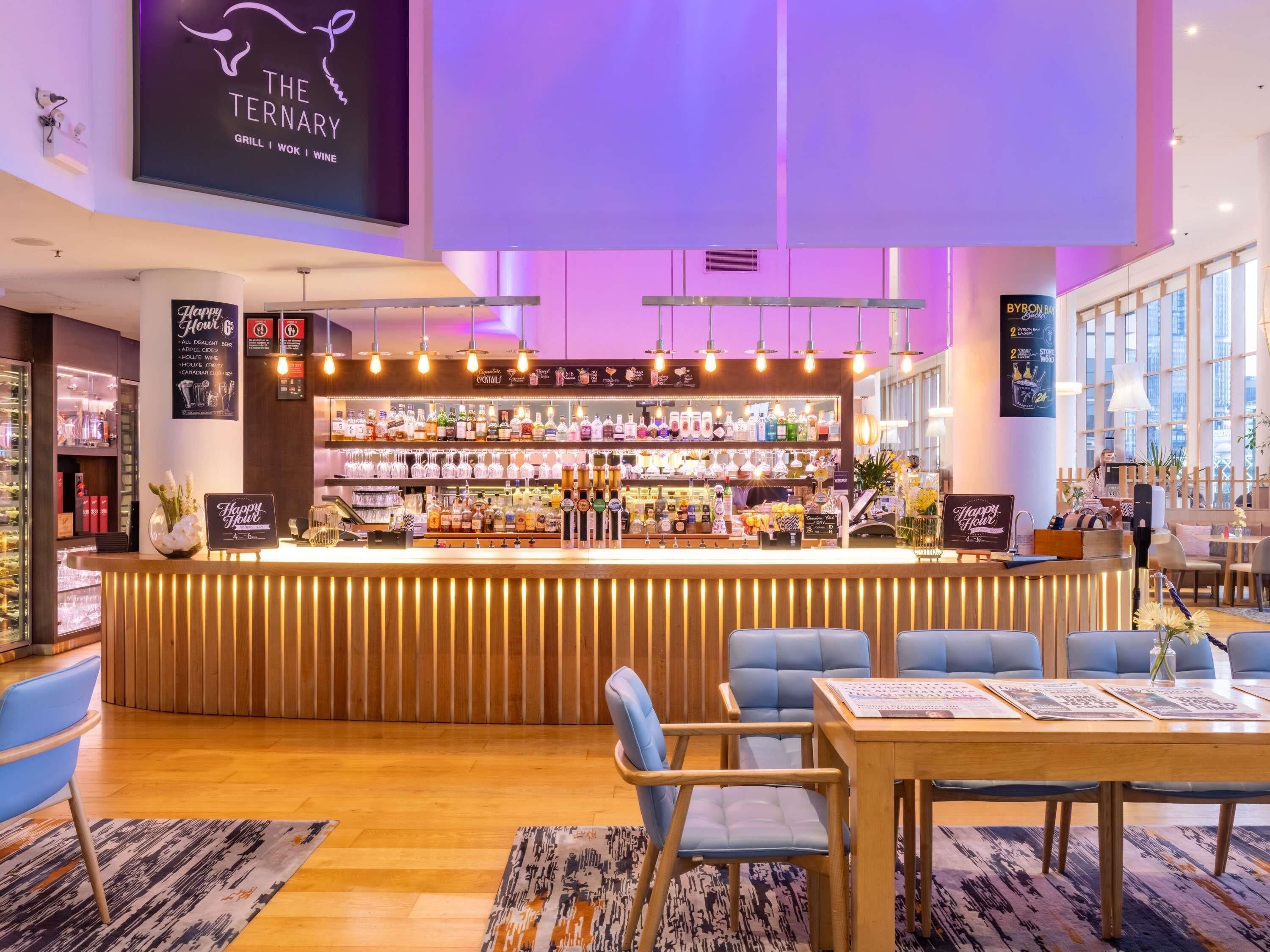 Un espace bar avec un comptoir, des sièges et un tableau affichant le menu.