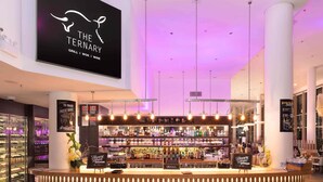 Un bar moderno con un letrero que dice 'The Tertry' y una variedad de botellas de licor.