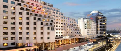 A modern hotel with multiple floors, a covered walkway, and a parking structure.