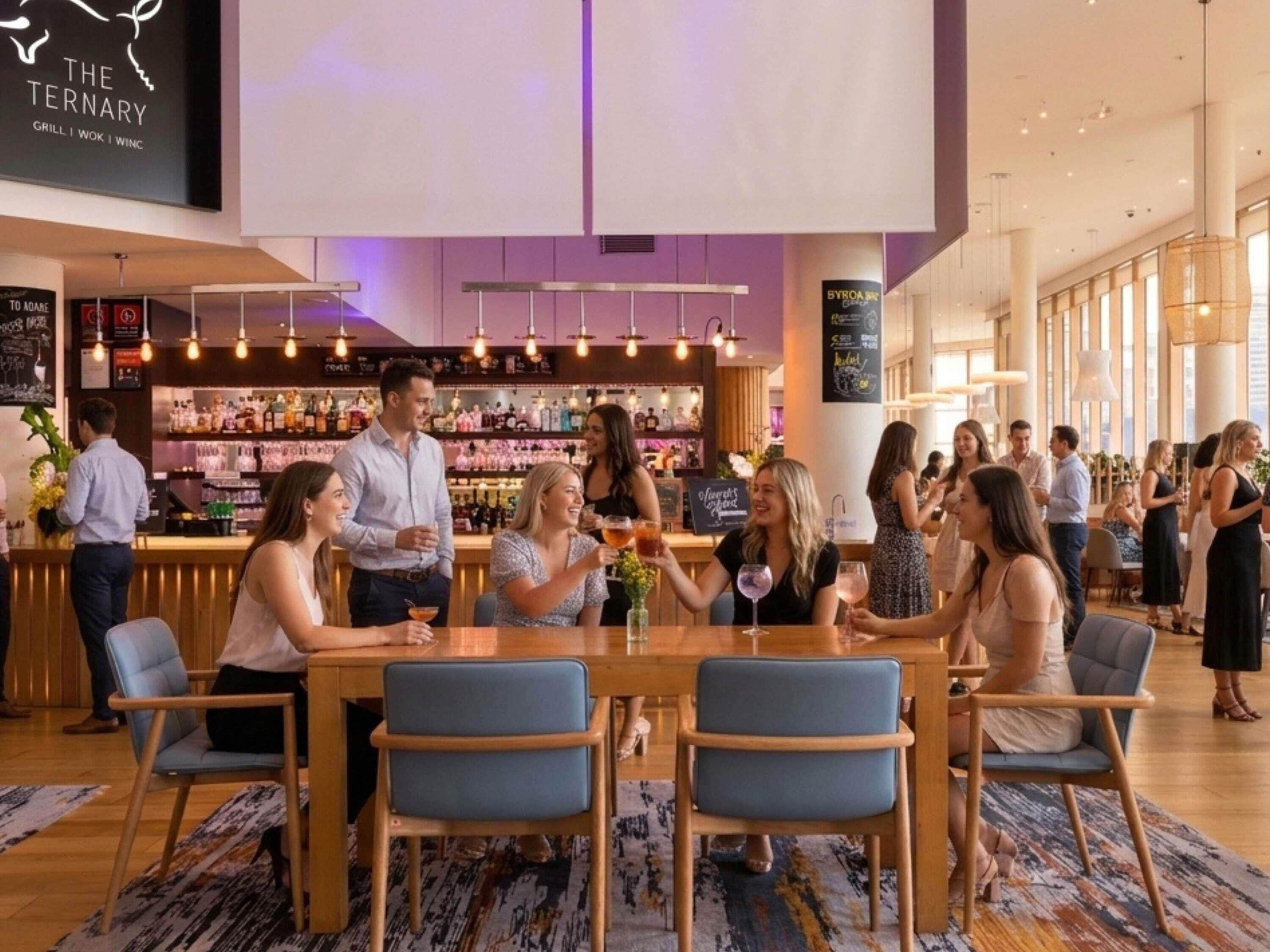 A bar area with a counter, seating, and a group of people.