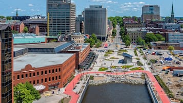 A cityscape with a prominent river, modern buildings, and a pedestrian bridge.