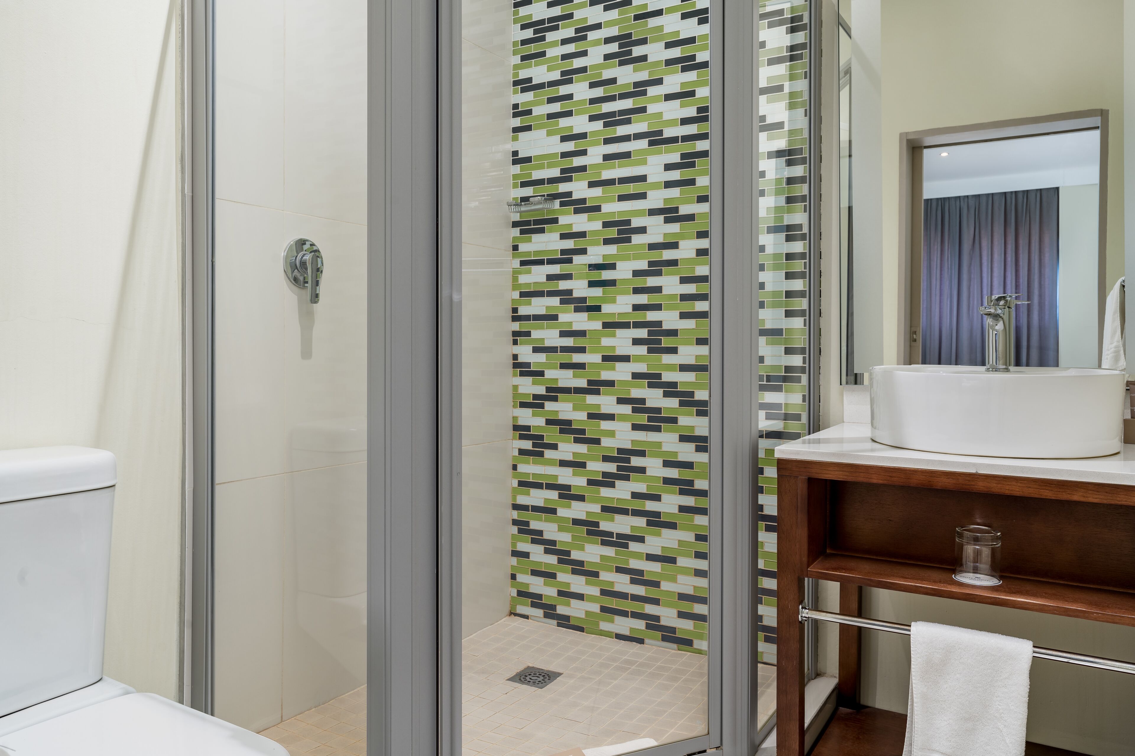 A modern bathroom with a shower enclosure, a sink, and a mirror.