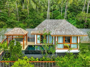 A two-story house with a swimming pool, surrounded by lush greenery and palm trees. - The Surin Phuket (Choeng Thale)