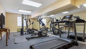 Un gimnasio con cintas de correr, bicicletas estáticas y máquinas de pesas.