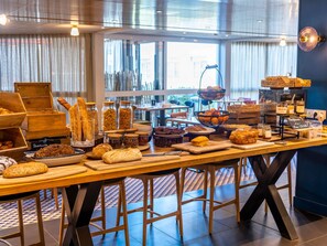 Mesa de buffet con diferentes alimentos y un cartel que indica 'Bons de la COCOTHE'.