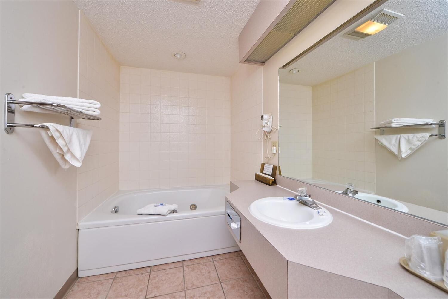 A bathroom with a bathtub, sink, and mirror.