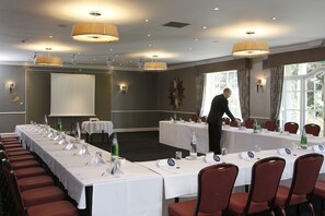 A conference room with long tables, nameplates, and red chairs. - Keavil House Hotel Dunfermline by Sunday (Dunfermline)