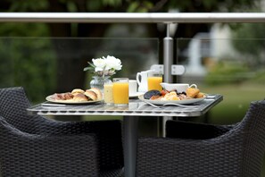 A breakfast table with croissants, a pitcher of orange juice, and a plate of eggs and bacon. - Keavil House Hotel Dunfermline by Sunday (Dunfermline)