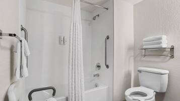 A bathroom with a shower, toilet, and grab bars.