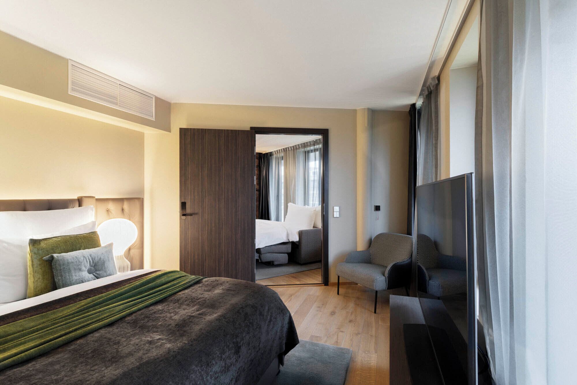 Une chambre d’hôtel avec un grand lit, un bureau, une chaise et un téléviseur.