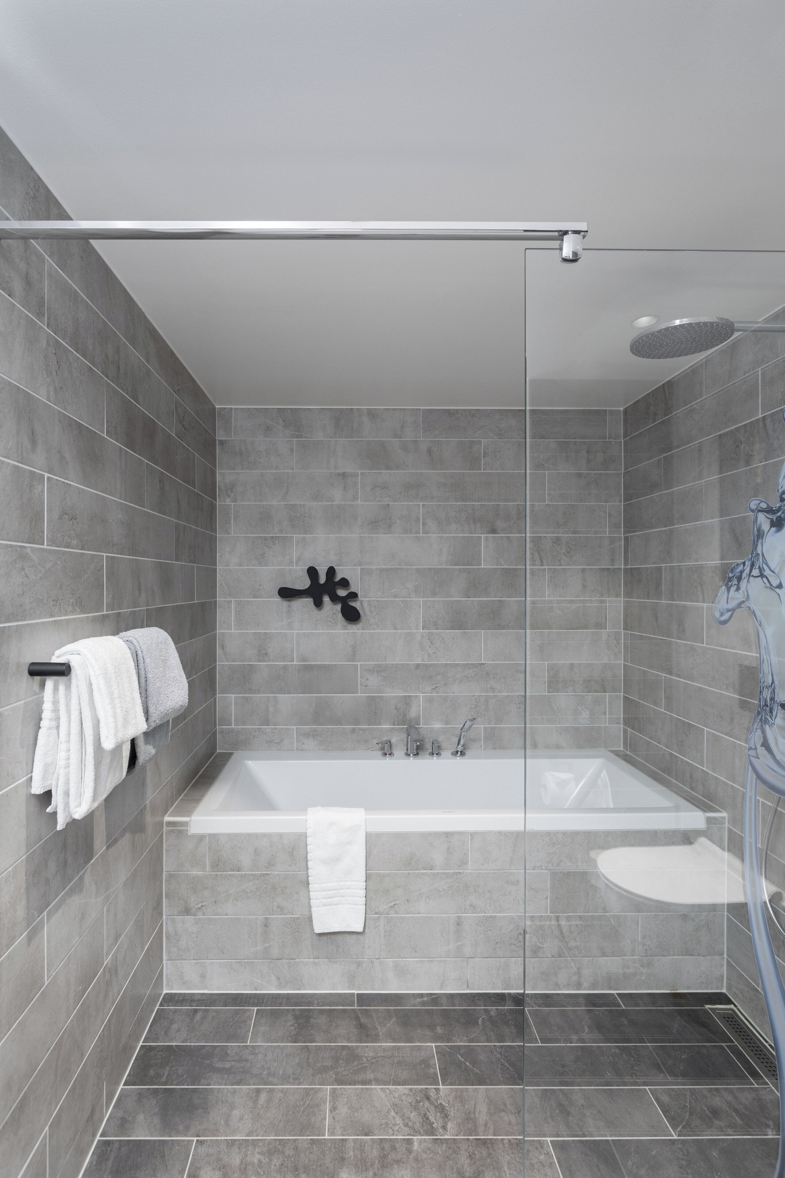 A modern bathroom with a glass-enclosed shower, a freestanding bathtub, and a separate sink.