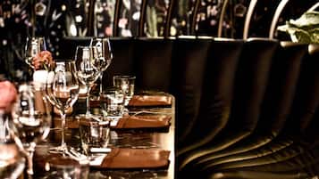 A bar area with a reflective surface, leather seating, and a floral wallpaper background.