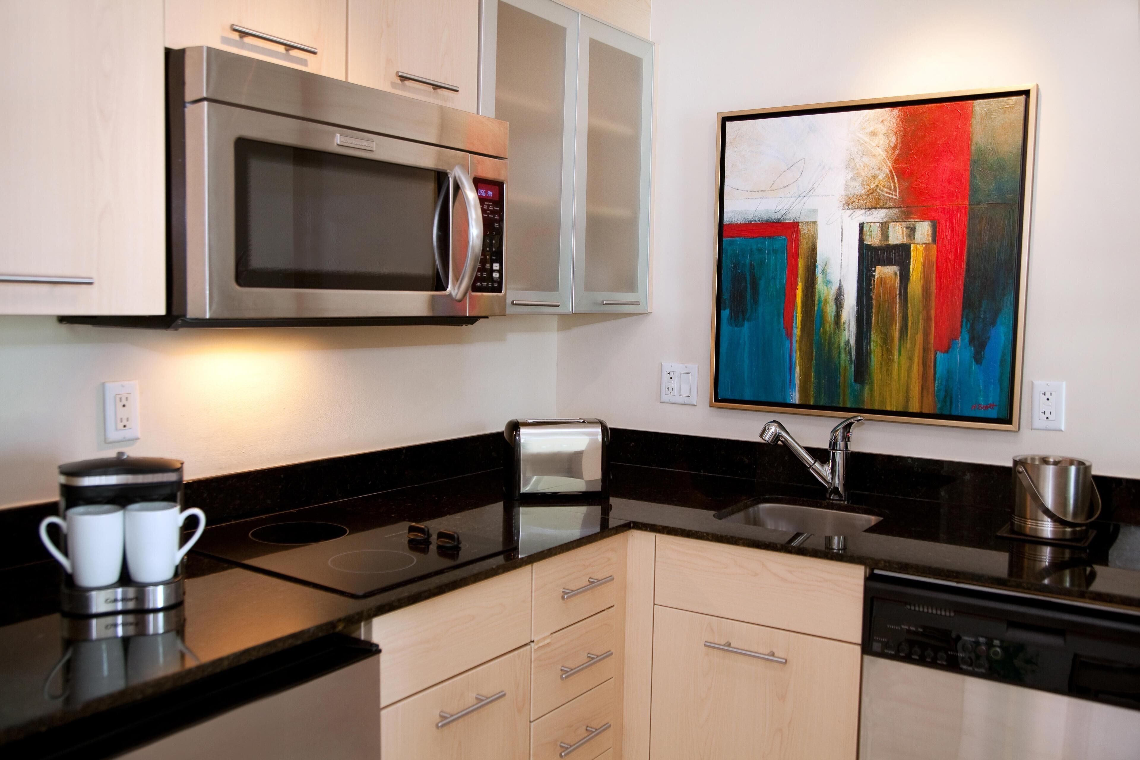 A modern kitchen with a built-in microwave, toaster, and dishwasher.