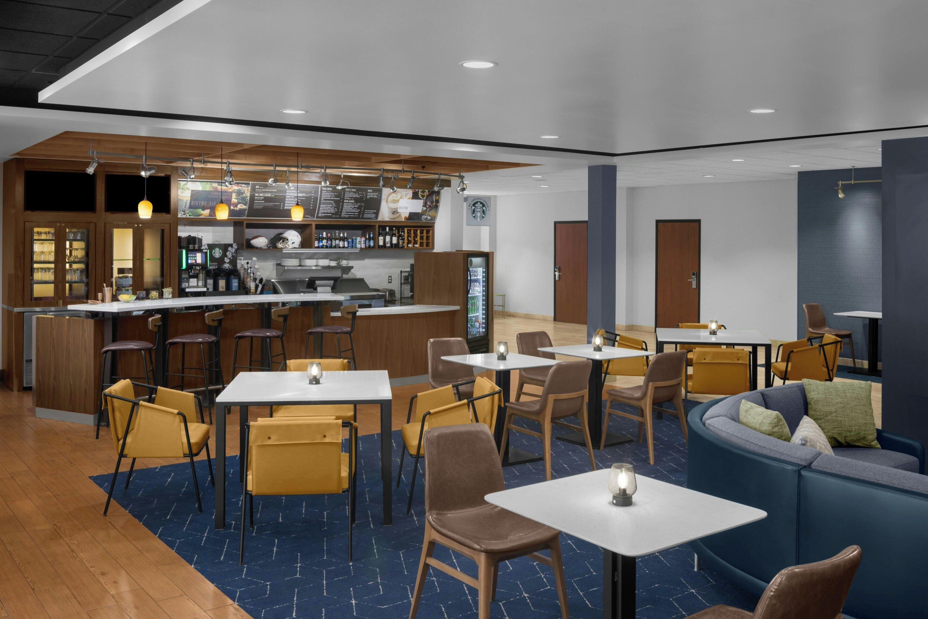 A modern restaurant with a bar area, seating arrangements, and a counter with a menu.