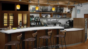 A modern bar area with a curved counter, bar stools, and overhead pendant lighting.