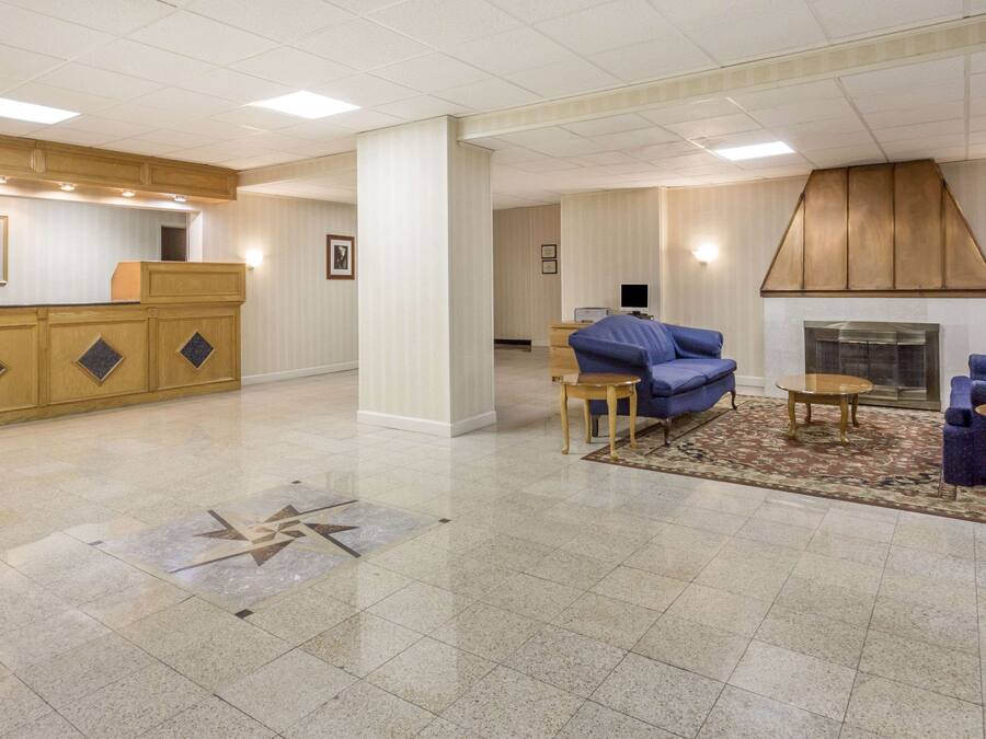 A hotel lobby with a reception desk, seating area, and a fireplace.