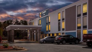 A Comfort Inn hotel with a covered entrance, multiple parking spaces, and a modern building facade.