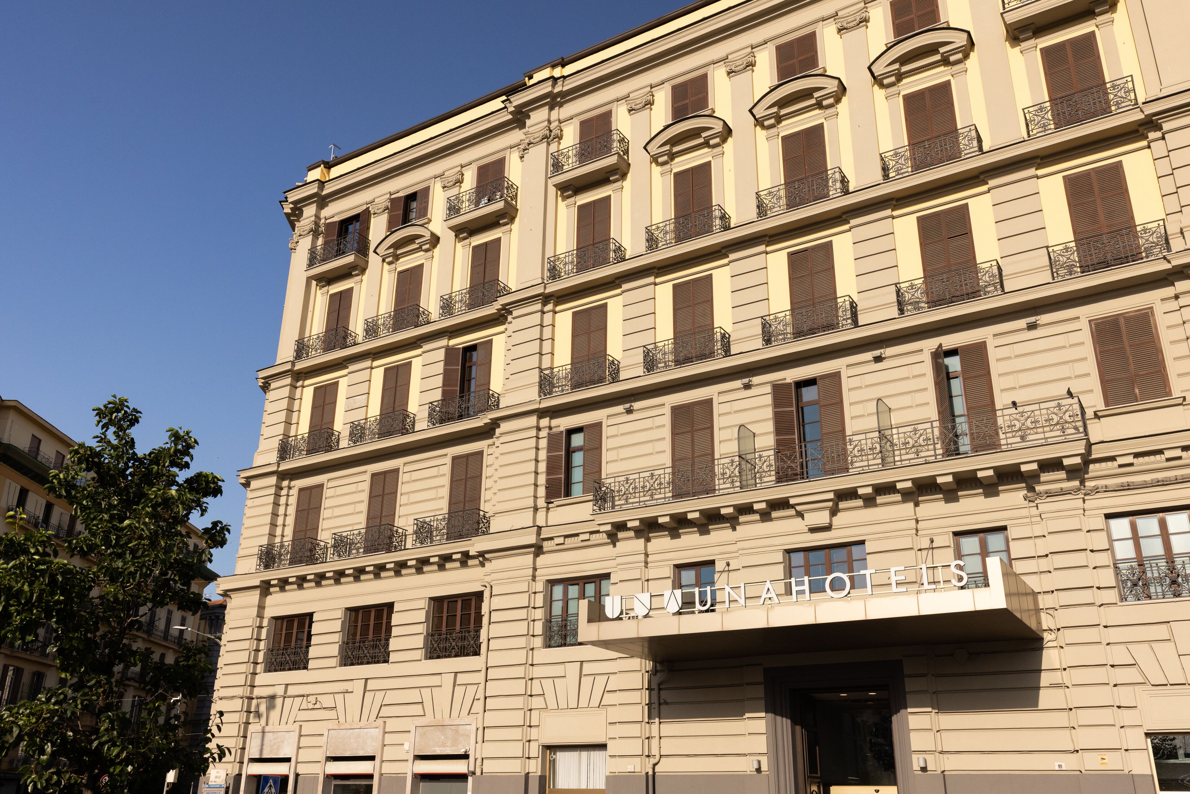 A multi-story hotel with a classic architectural style, featuring balconies and a prominent entrance.