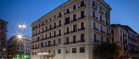 A multi-story hotel with a classic architectural design, featuring balconies and a prominent entrance.