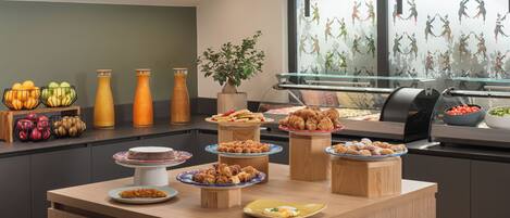 A buffet with various food items and a potted plant.
