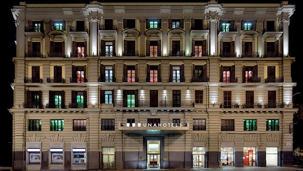 A multi-story hotel with a classic architectural style, featuring balconies and a prominent entrance. - UNA Hotels Napoli (Naples)