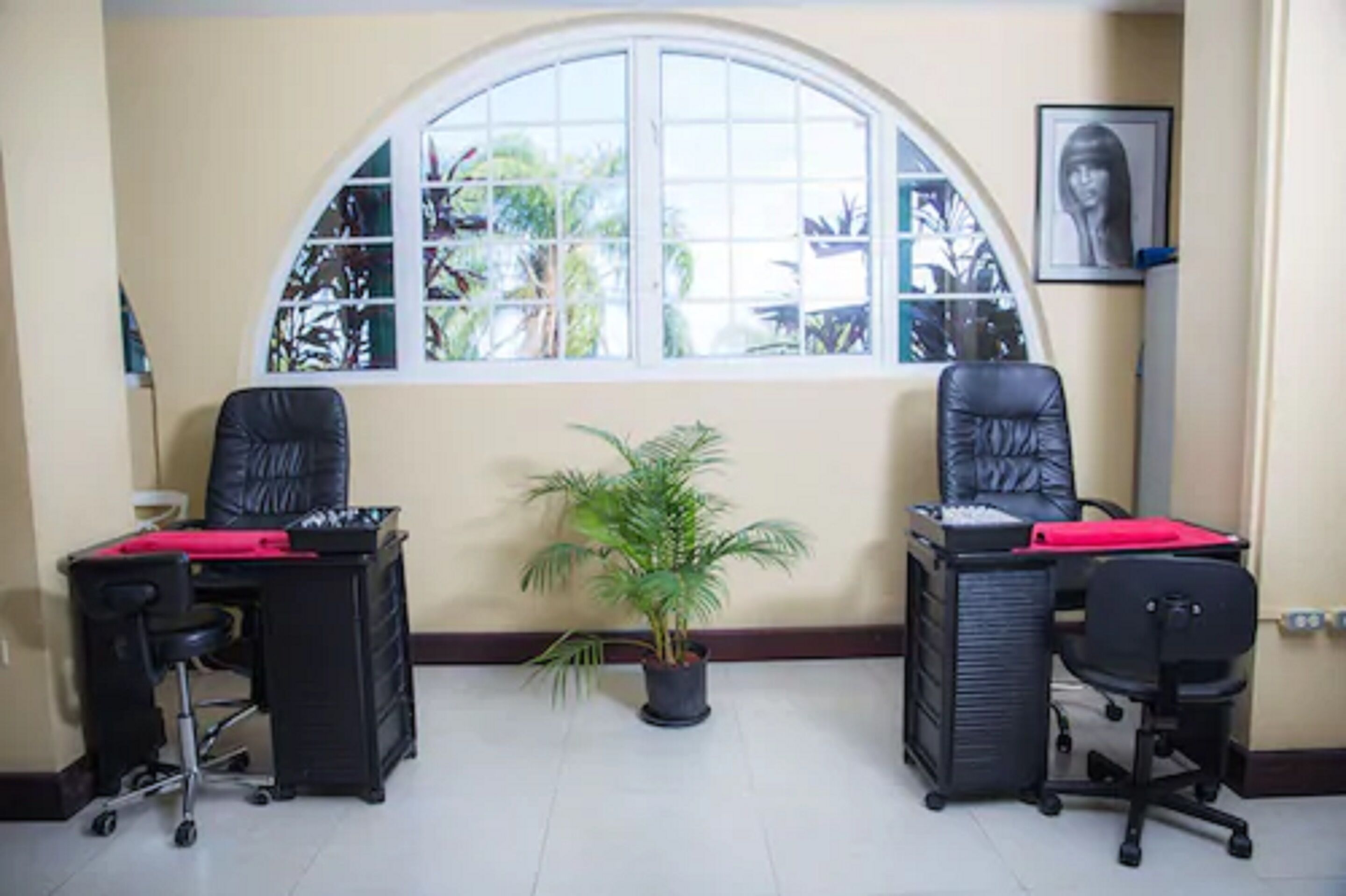 A room with two black office chairs, a desk with a red folder, and a potted plant.
