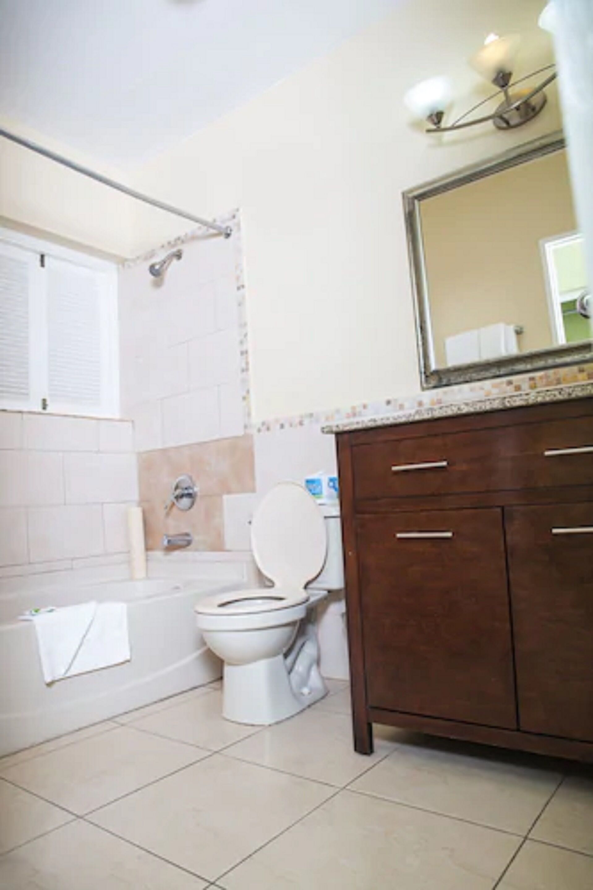 Un baño con inodoro, bañera y tocador con cajones.