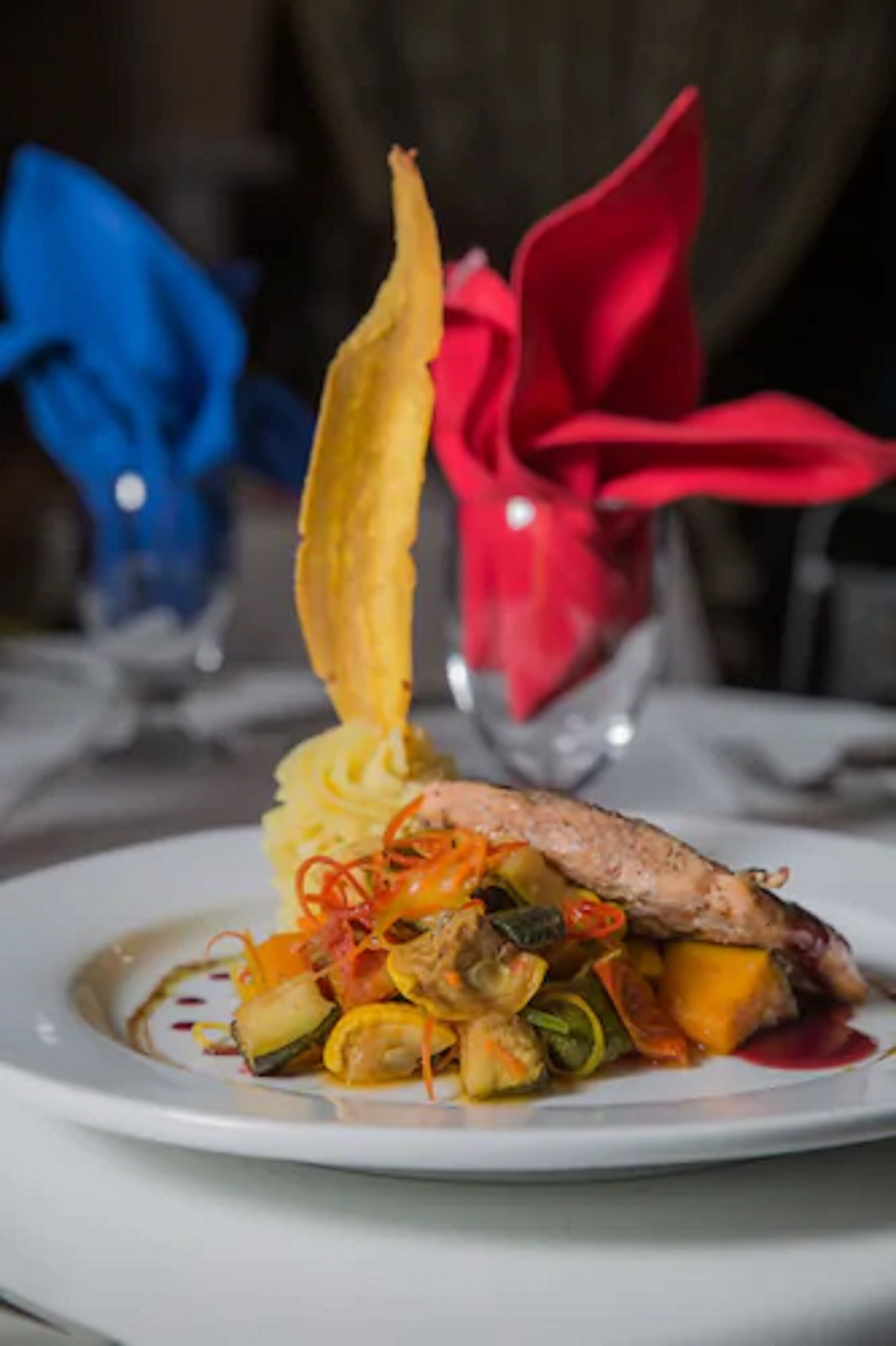 Un plato de comida con carne, verduras y un adorno.