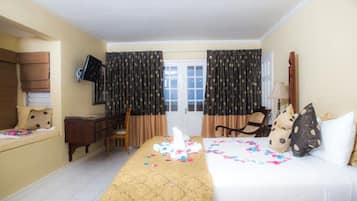 A hotel room with a bed, a desk, a chair, a television, and curtains.