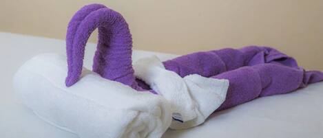 A white and purple towel folded on a white surface.