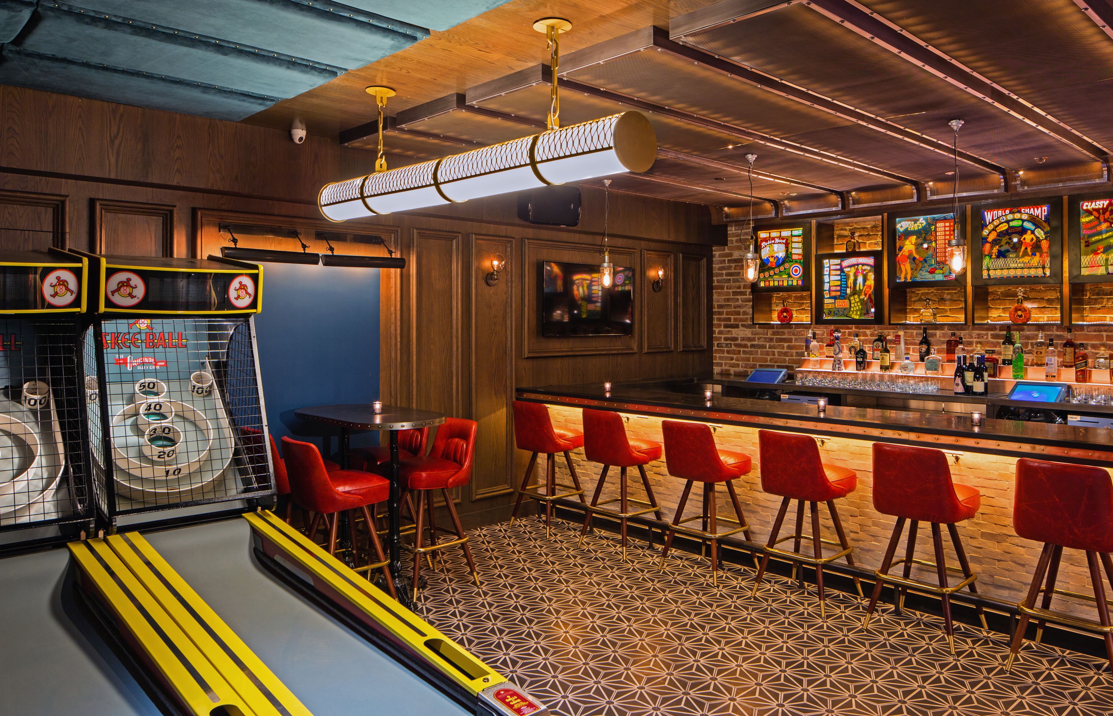 A bar area with stools, a counter, and arcade games.