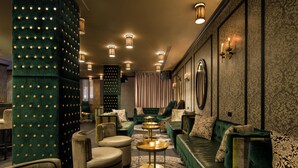 A luxurious lounge area with plush seating, a patterned rug, and ambient lighting.
