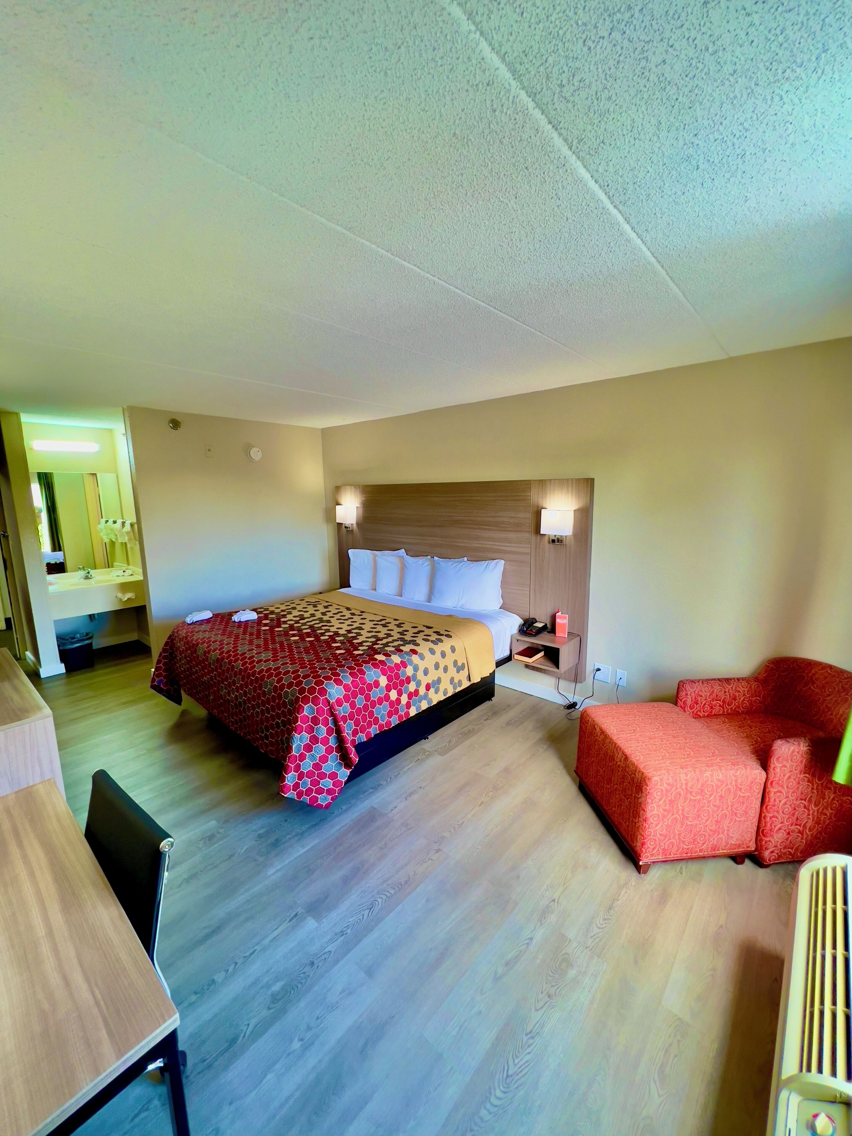 Une chambre d’hôtel comprenant un lit, des tables de chevet, un bureau et une chaise.