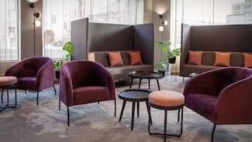 Un área de estar moderna con asientos cómodos, una mesa de centro y una planta en maceta.