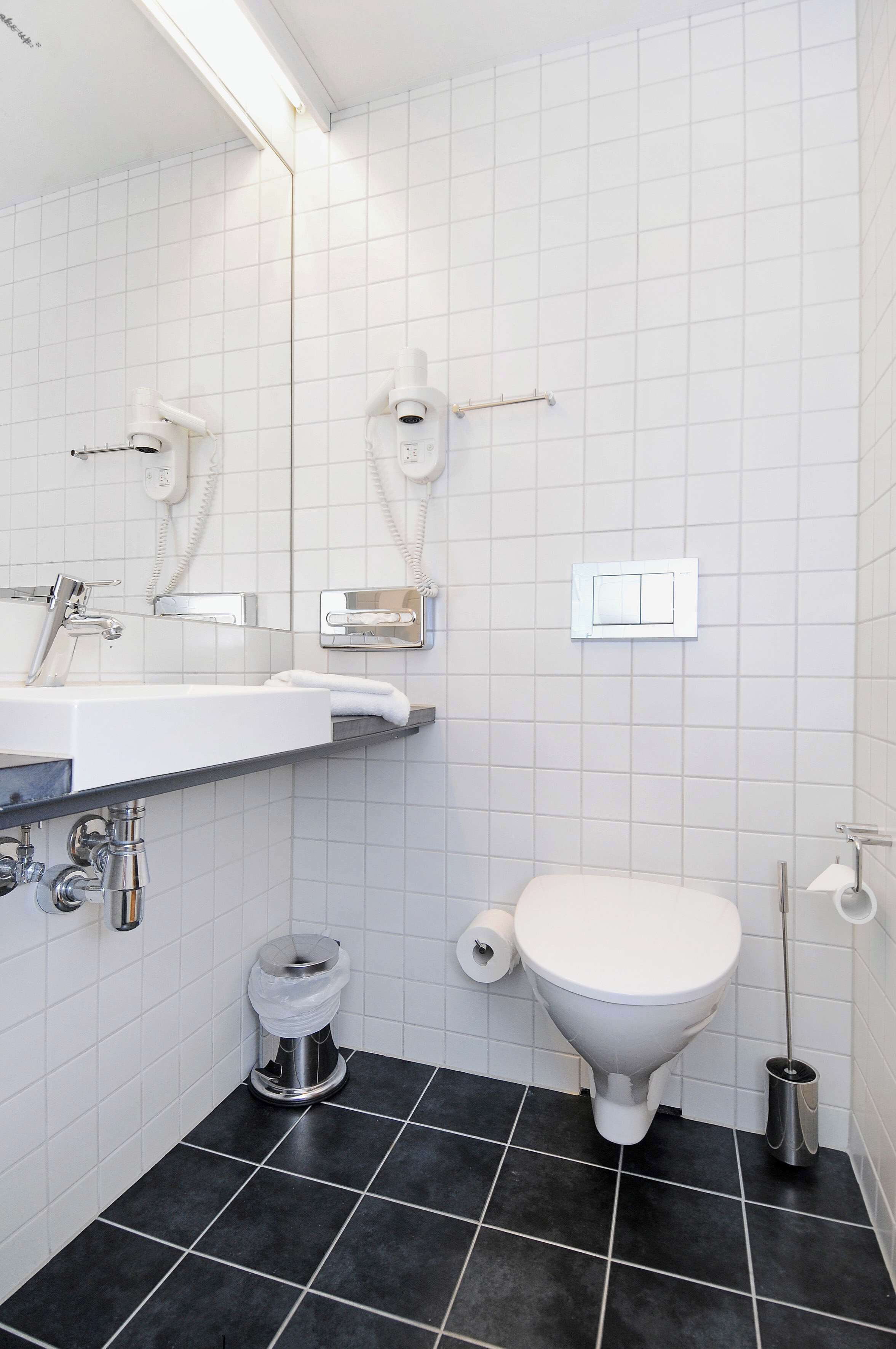 A bathroom with a white sink, a toilet, and a bidet.