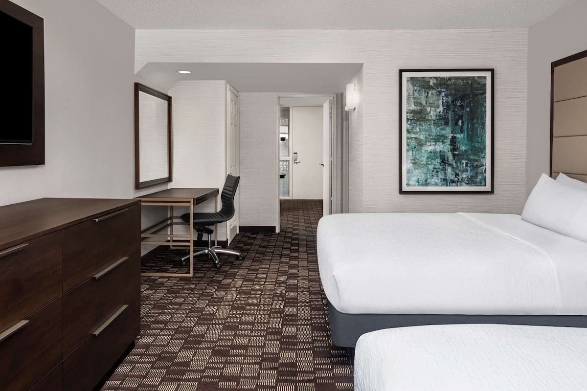 Ein Hotelzimmer mit Bett, Schreibtisch, Stuhl und Kommode.