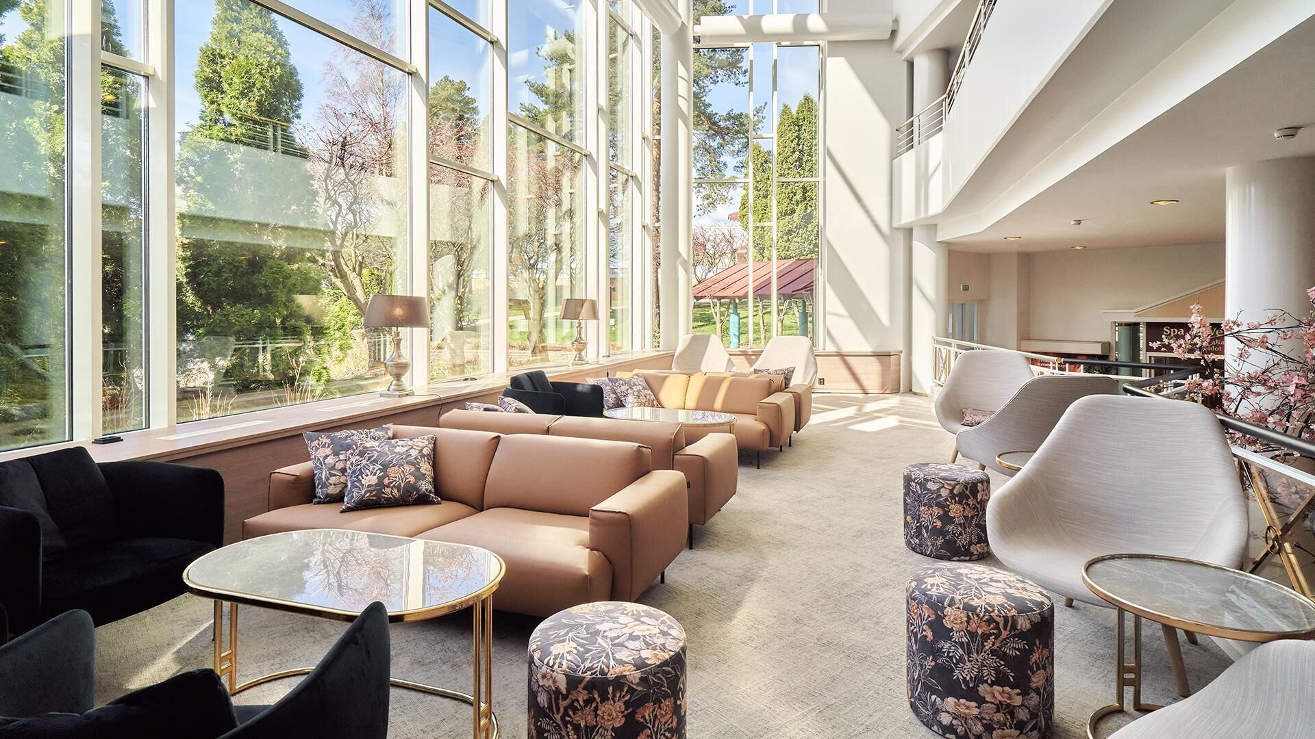 A spacious lounge area with large windows, comfortable seating, and a view of the outdoors.