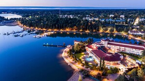 An aerial view of a lakeside hotel with a marina, surrounded by dense forest, featuring a large building with a red roof and multiple balconies. - Naantali Spa Hotel (Naantali)