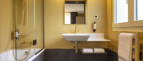 A modern bathroom with a bathtub, a sink, and a shower.