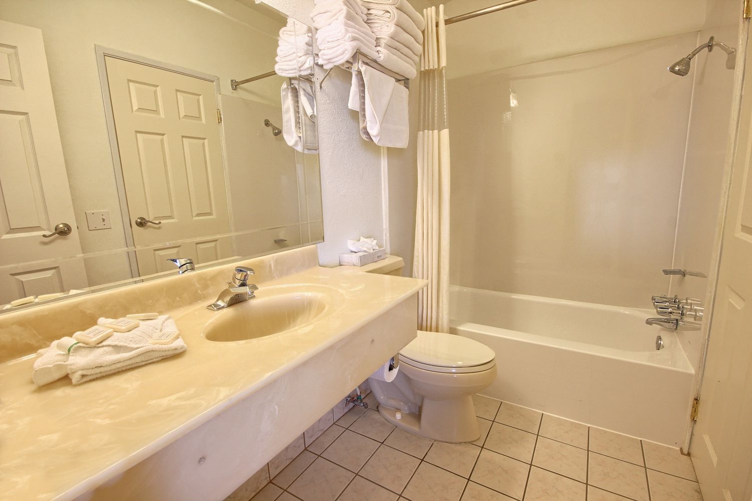 A bathroom with a double sink vanity, a toilet, a bathtub, and a shower.