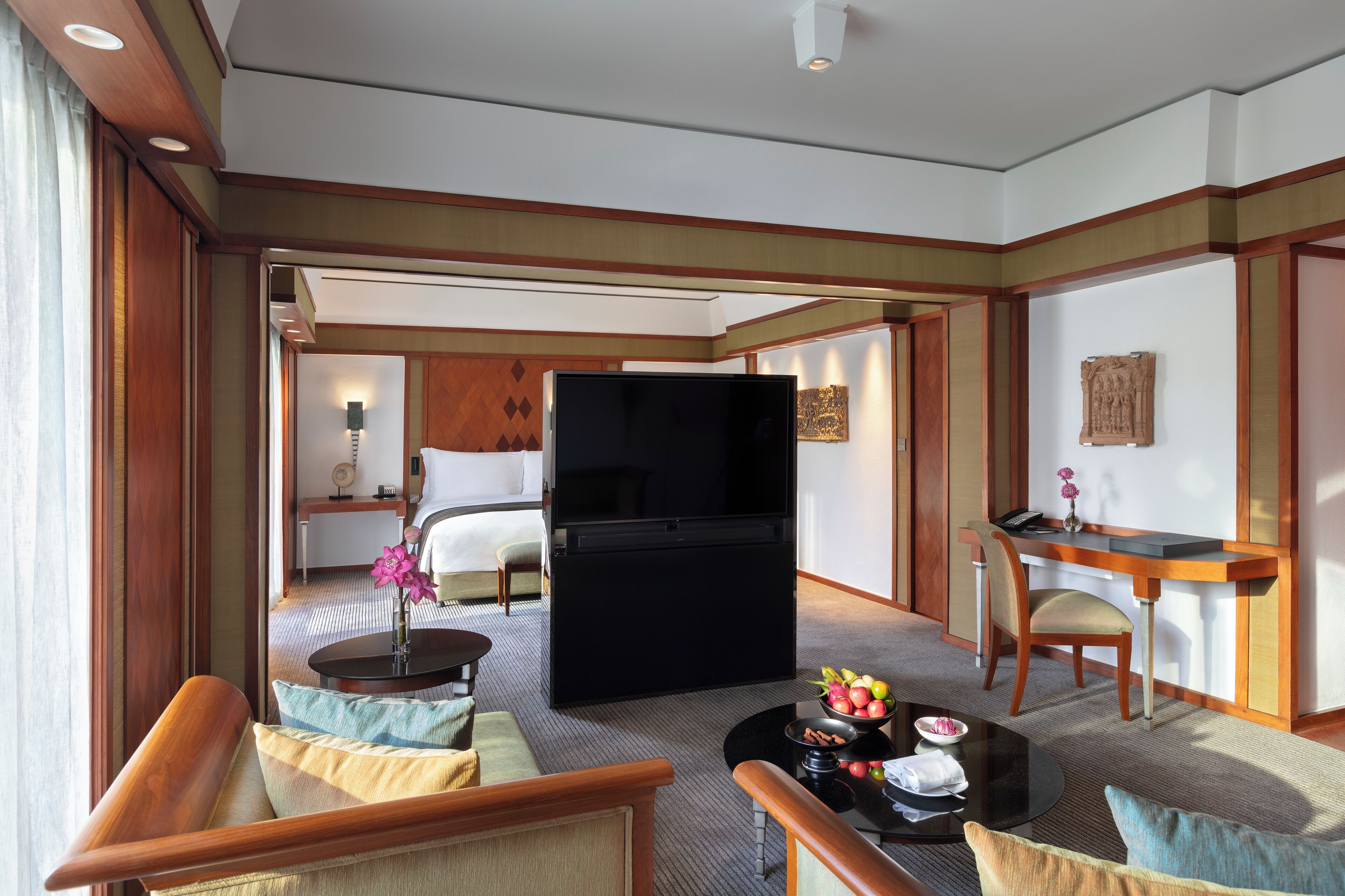 Ein Hotelzimmer mit einem Bett, einem Fernseher, einem Schreibtisch und einer Sitzecke mit Couchtisch.