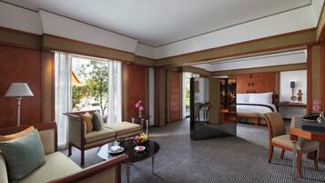 A hotel room with a sofa, a dining table, a bed, and a view of the outdoors.