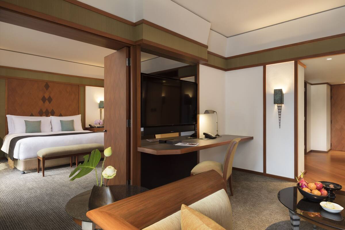 A hotel room with a bed, desk, and seating area.